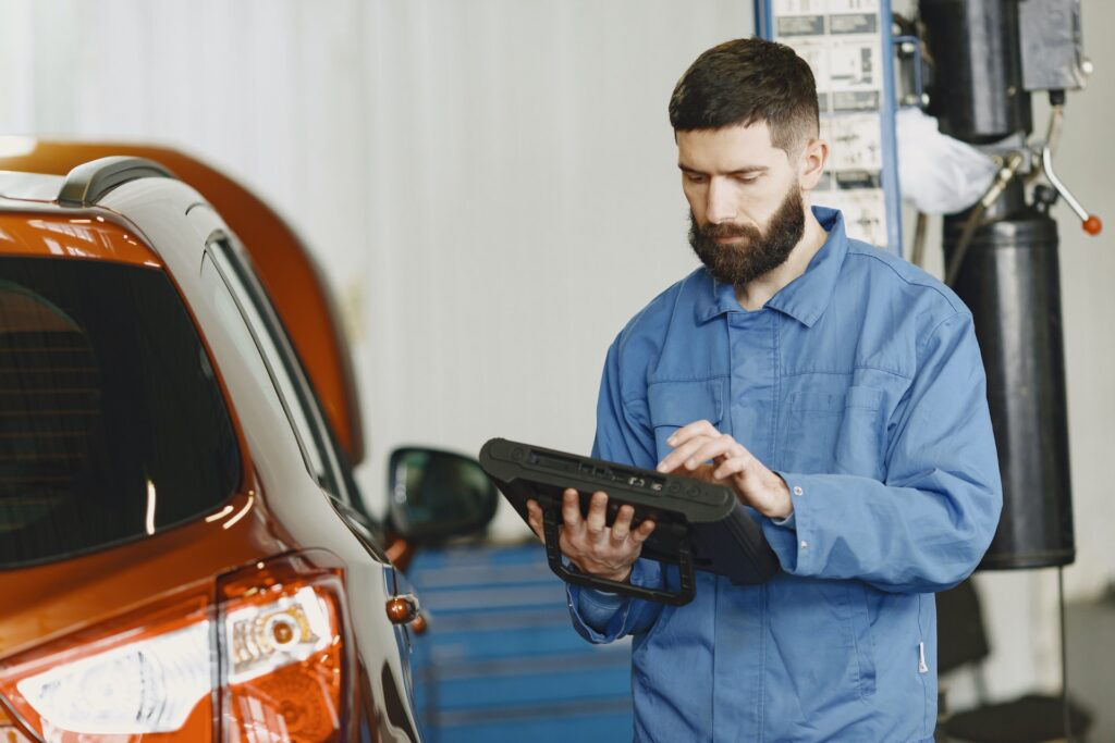 automekaniker med obd tester i hånden